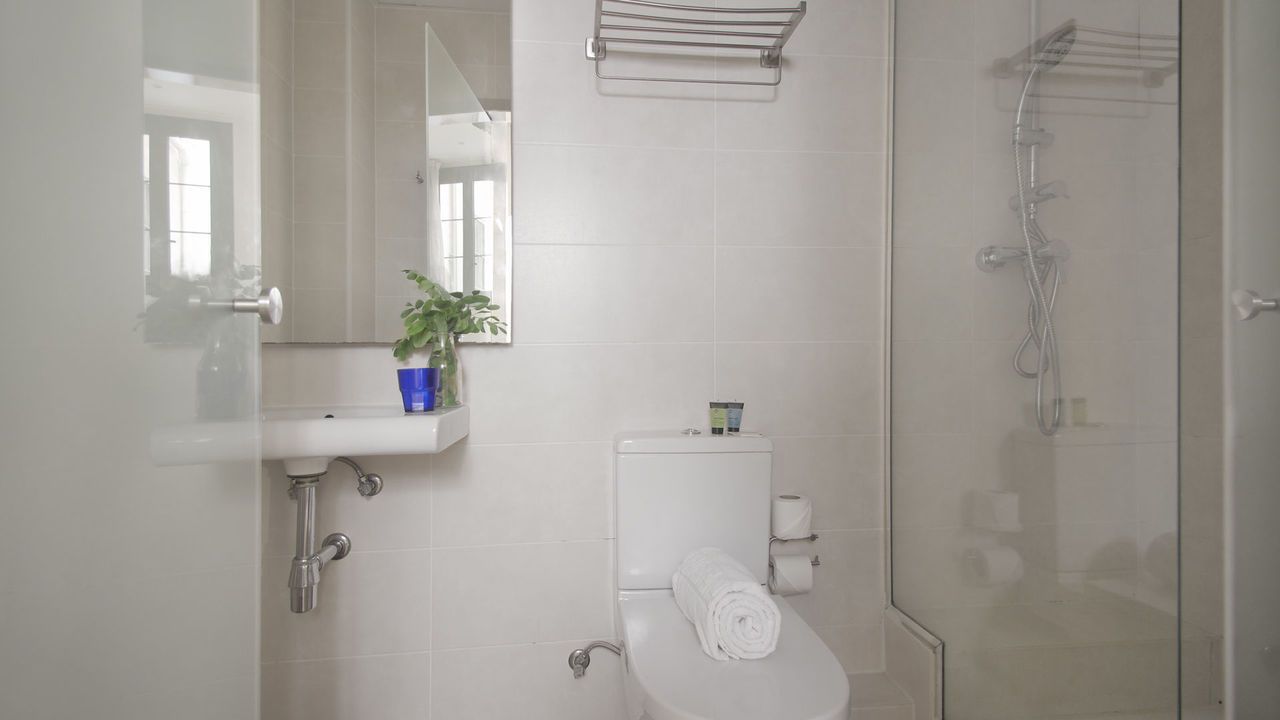 Un baño con inodoro, lavabo y ducha.