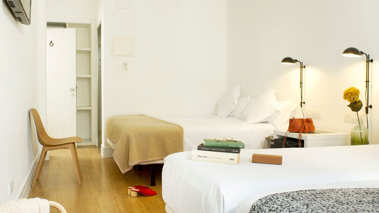 Una habitación de hotel con dos camas y una silla.