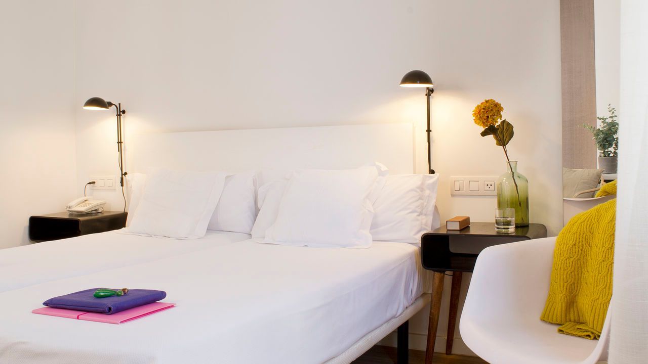 Un dormitorio con una cama grande y una silla.