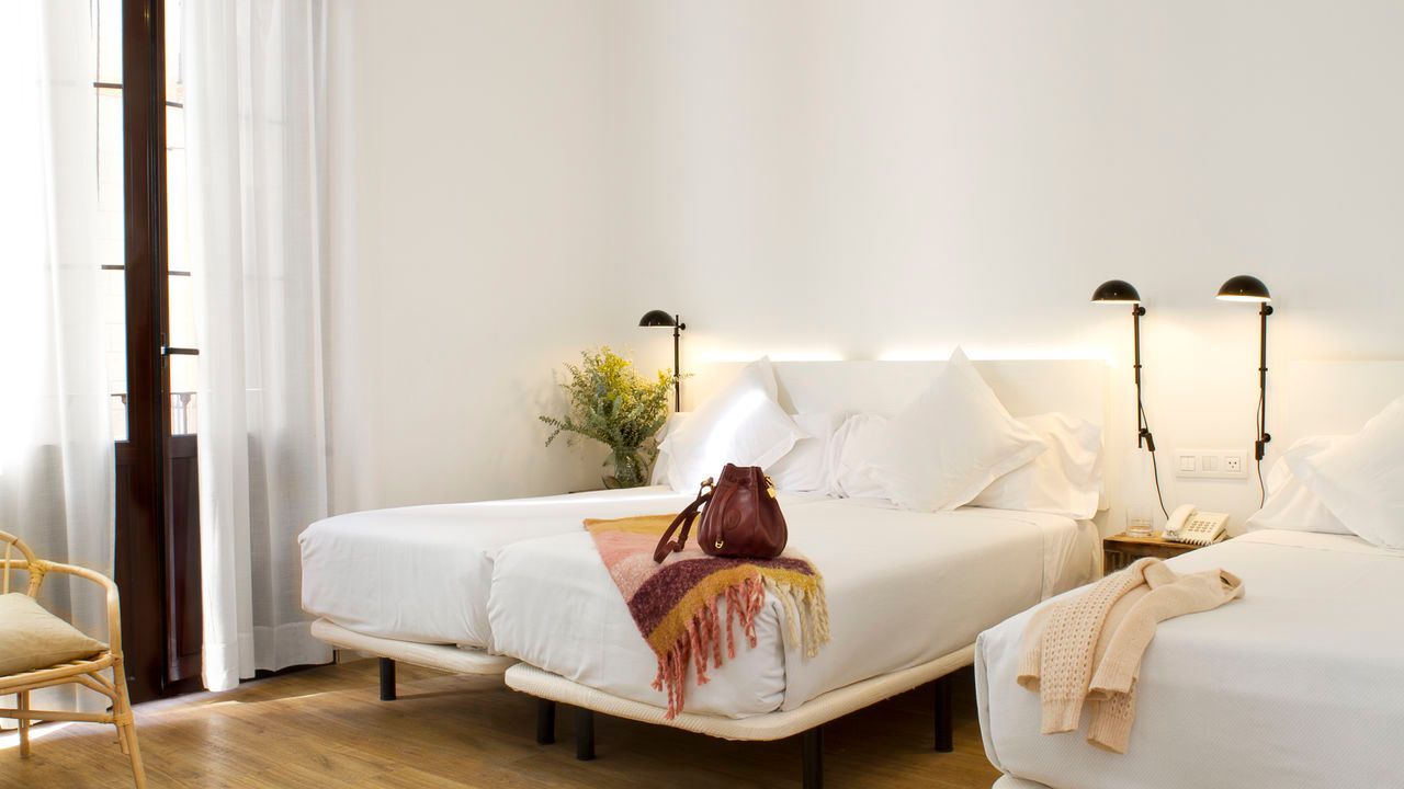 Una habitación de hotel con dos camas y una silla.