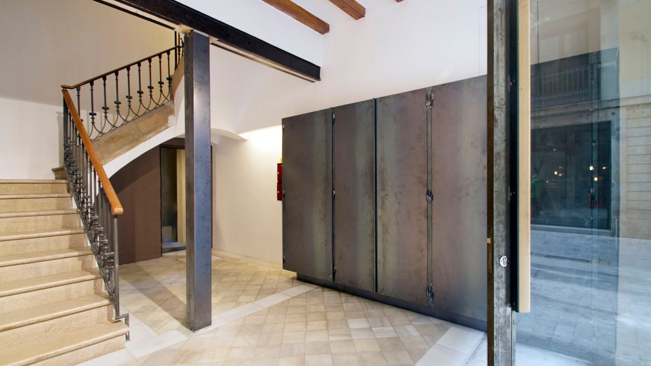 Un pasillo con escaleras que conducen al segundo piso de un edificio.