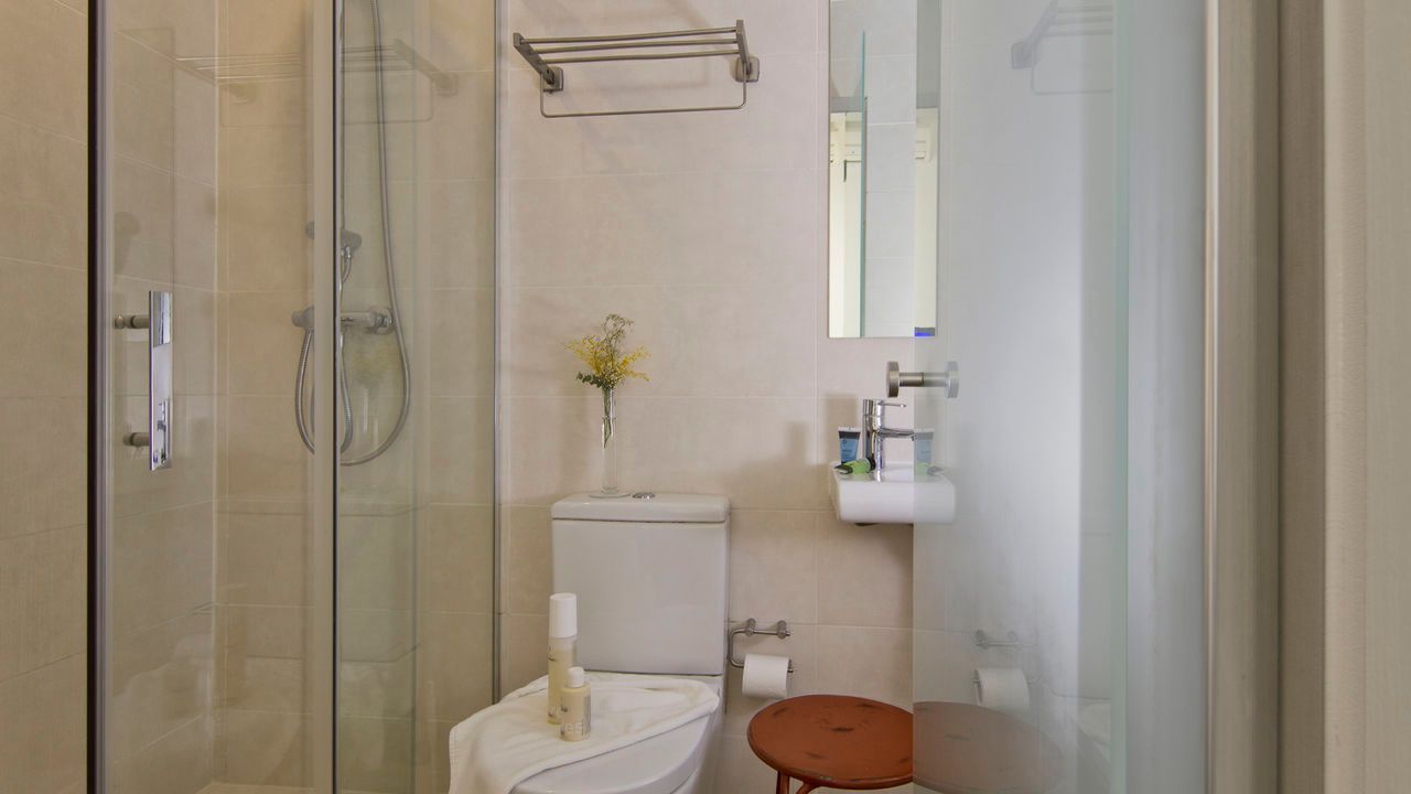 Un baño con inodoro, lavabo y ducha.