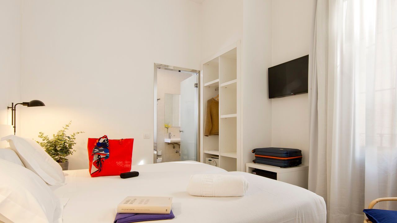 Una habitación de hotel con una cama grande y un televisor de pantalla plana.