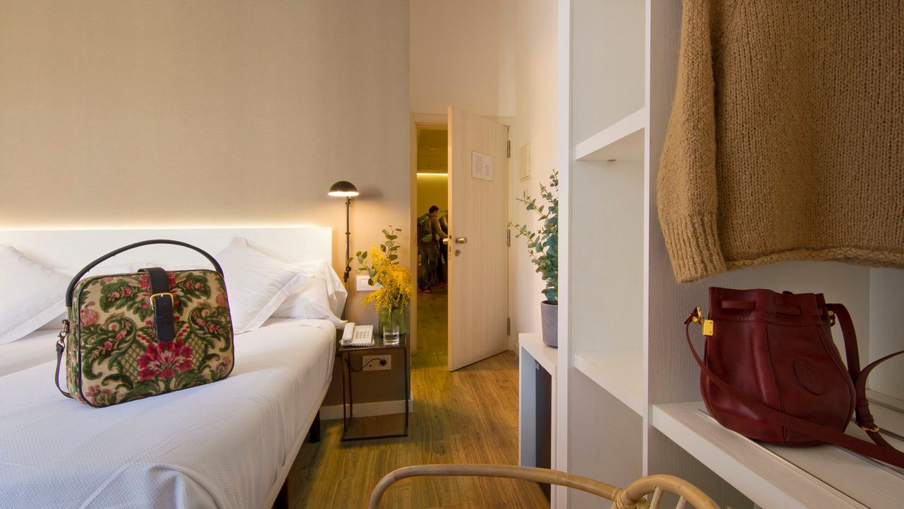 Un dormitorio con una cama y un bolso sobre la cama.