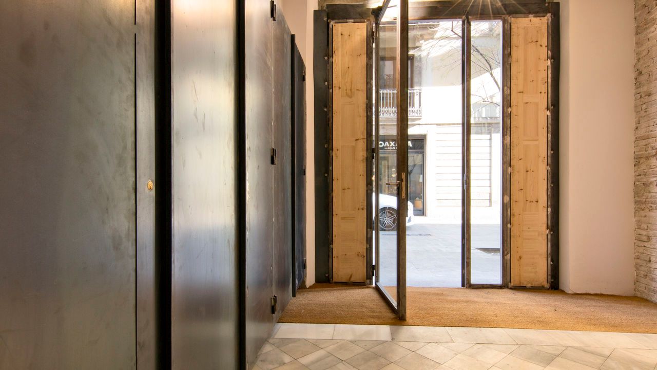 Una habitación vacía con una puerta de madera y una puerta de metal.