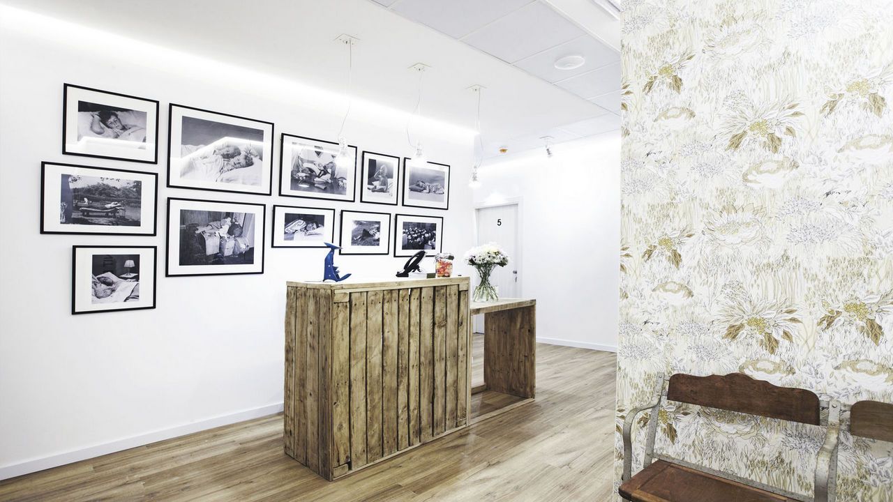Una habitación con un mostrador de madera y una fila de cuadros en la pared.