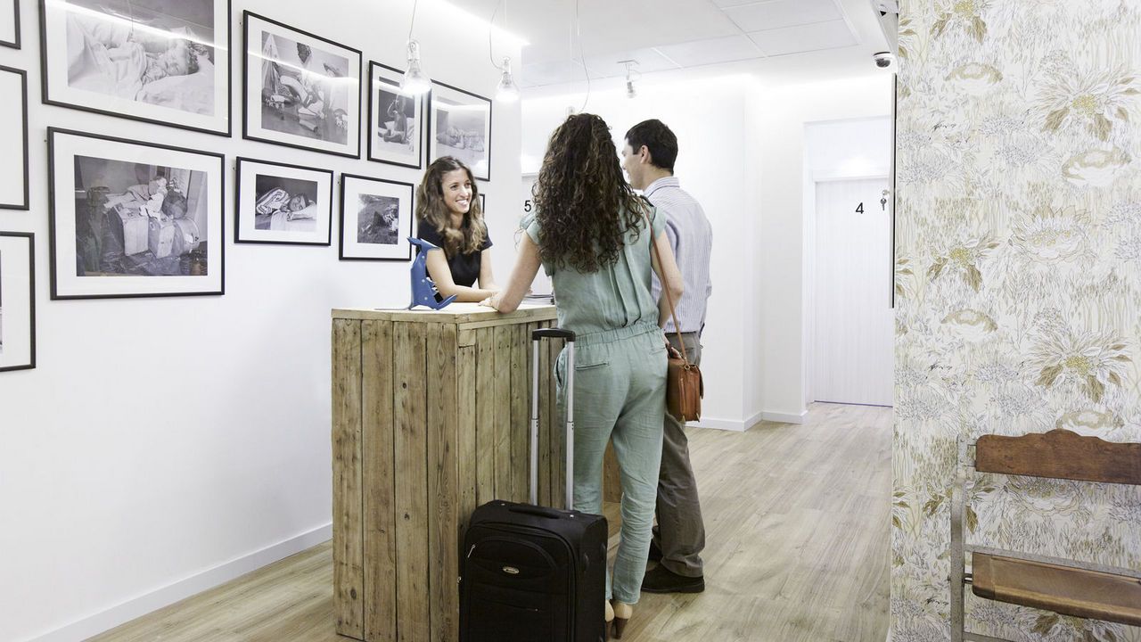 Un hombre y una mujer están de pie ante un mostrador en una habitación.