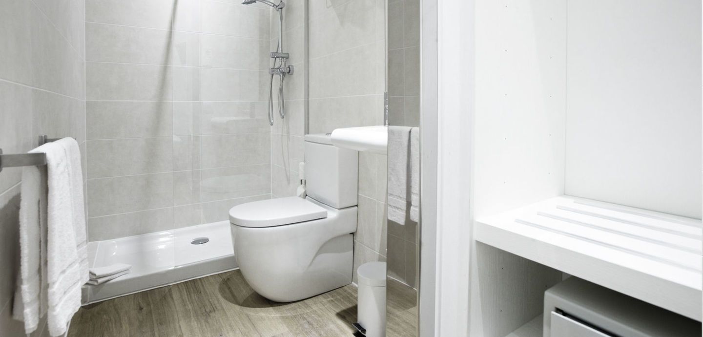 Un baño con inodoro, lavabo y ducha.