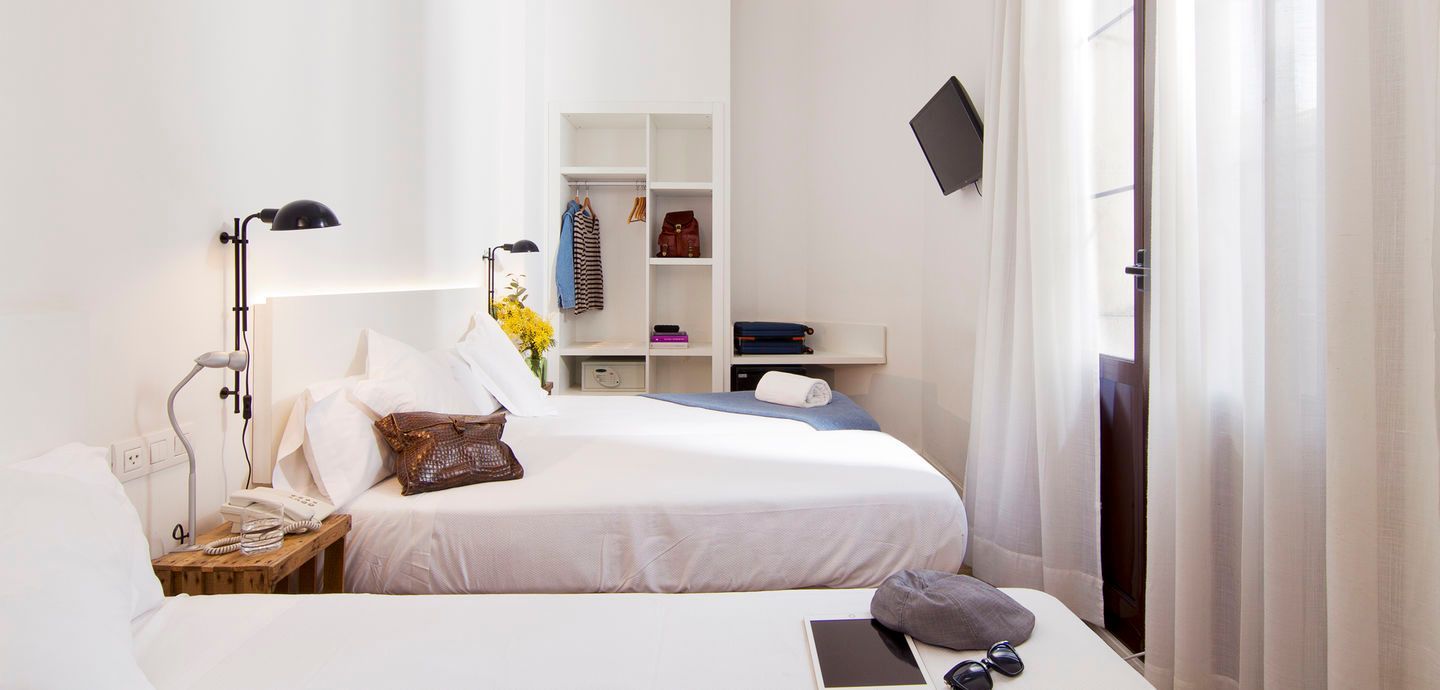 Una habitación de hotel con dos camas y una ventana.