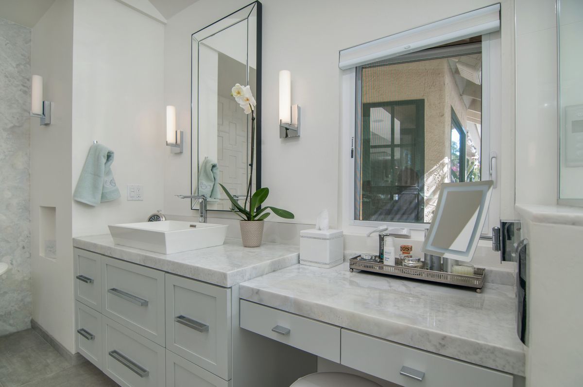 A bathroom with two sinks , a vanity , and a mirror.