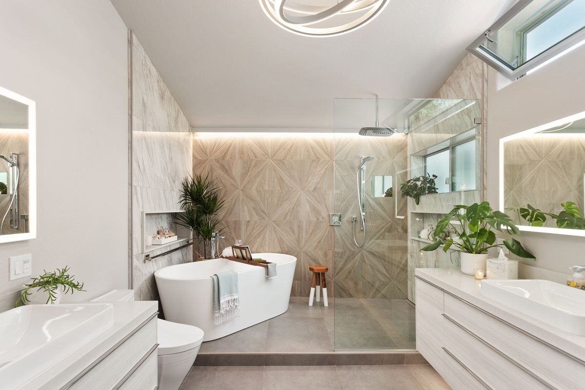 A bathroom with a bathtub , toilet , sink and shower.