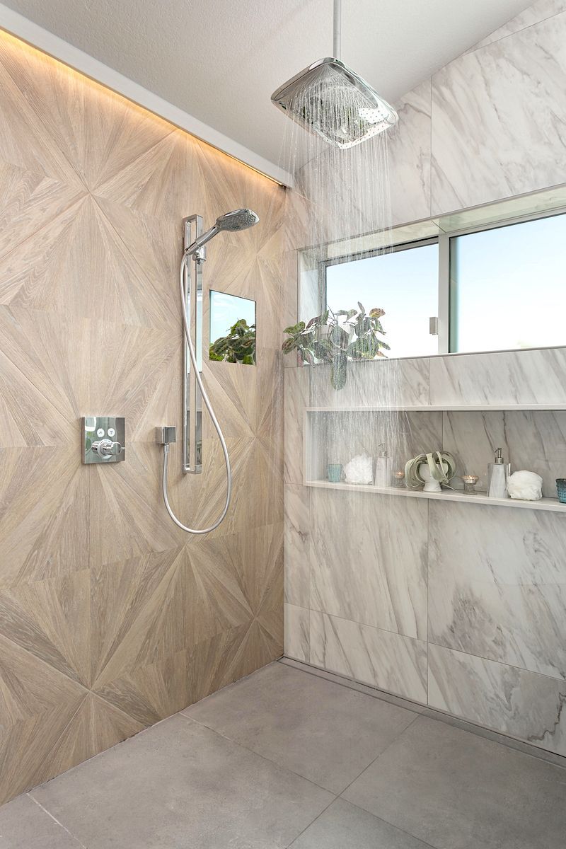 A bathroom with a walk in shower and a window.