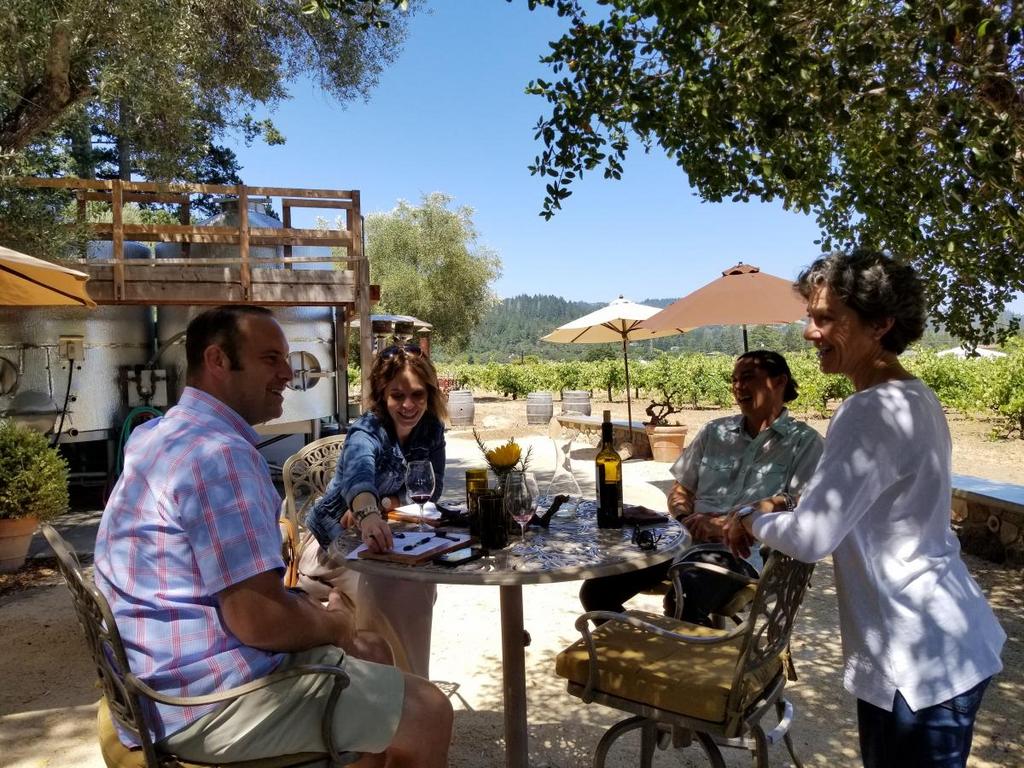 people enjoying outside the vineyard enjoying wine