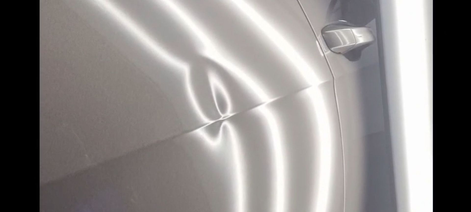 a close up of a car door with a dent in it