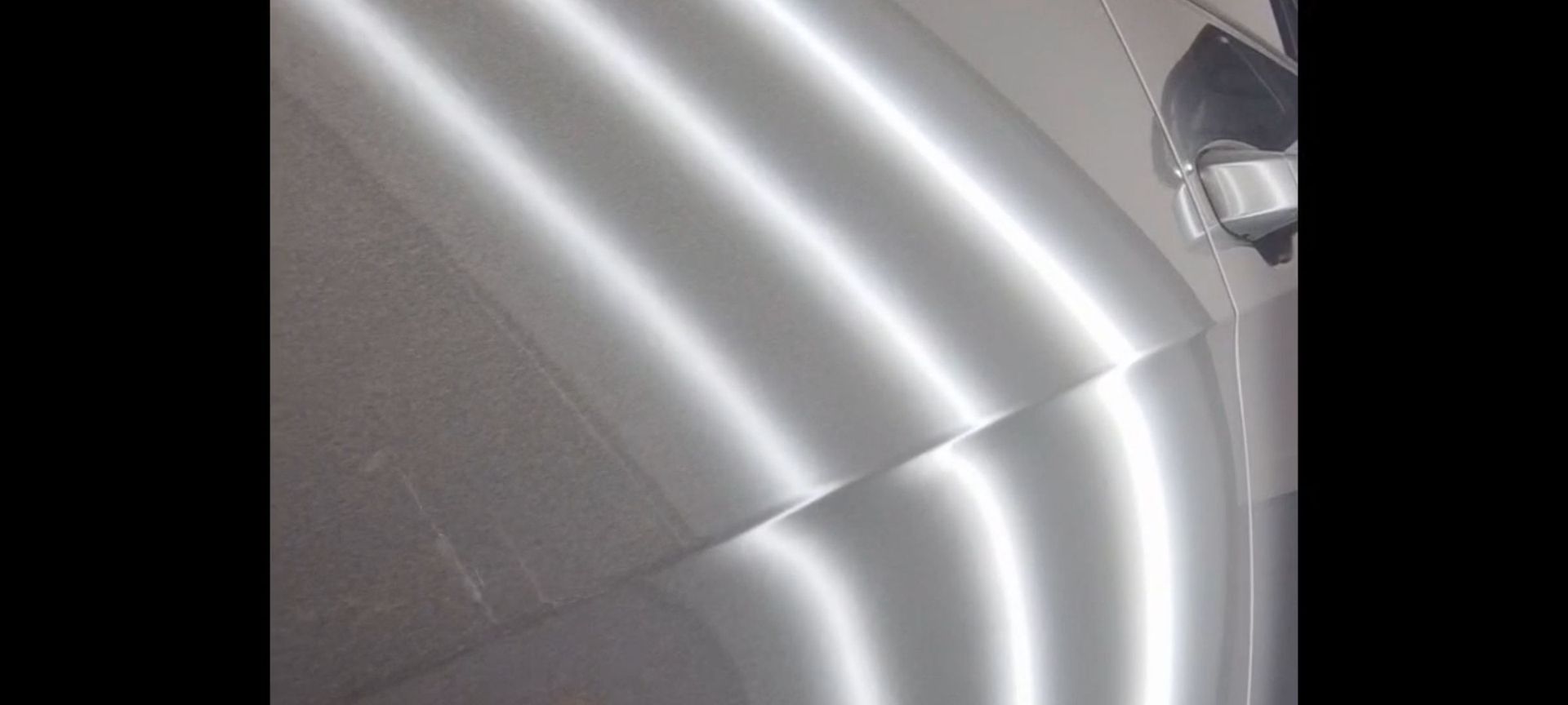 a close up of a car door with dents removed by Xquisite paintless dent removal