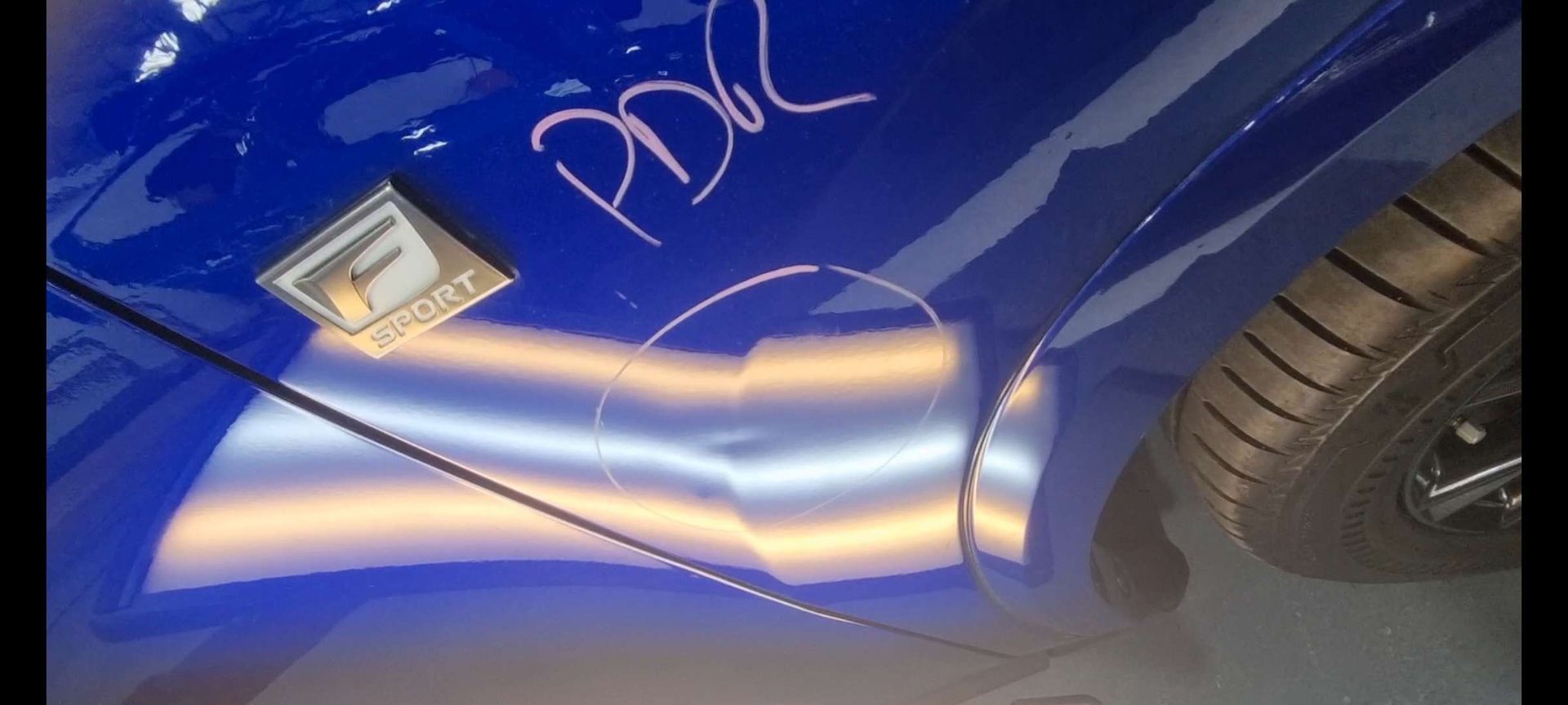 a blue car with dents that need to be fixed