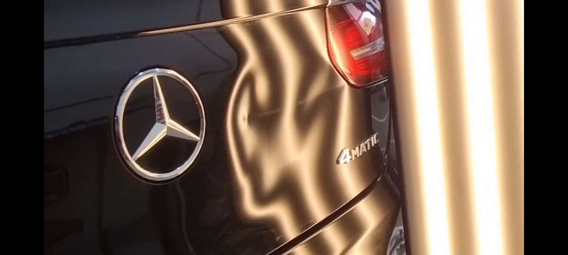 a black mercedes with dents on it