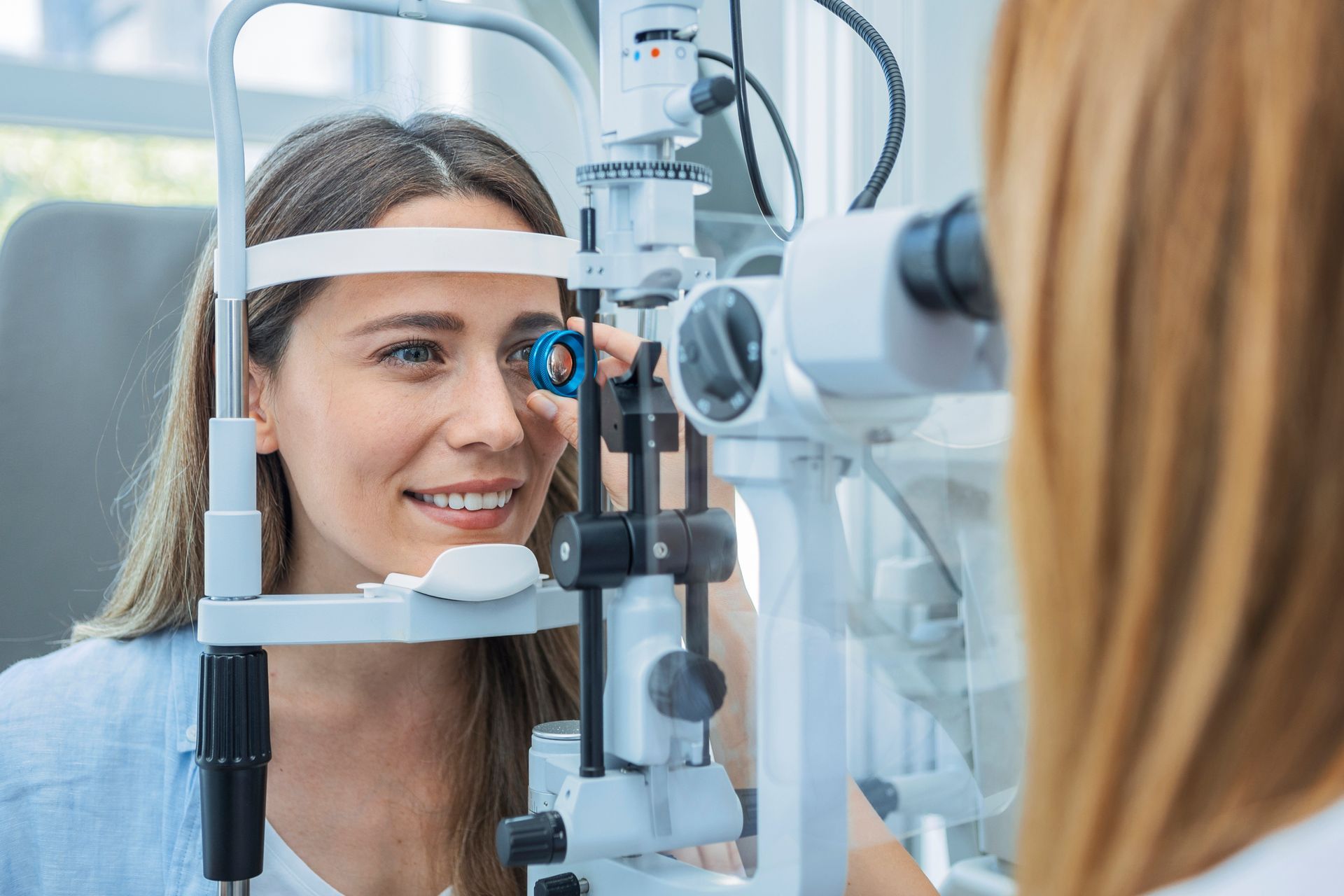Woman getting an eye exam using a slit lamp. Doctor is examining the patient's eye.