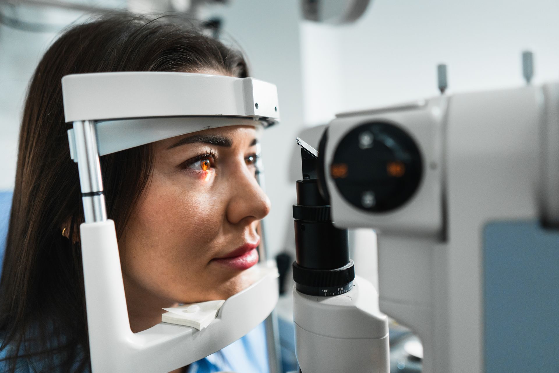 Woman undergoing eye exam with medical equipment.