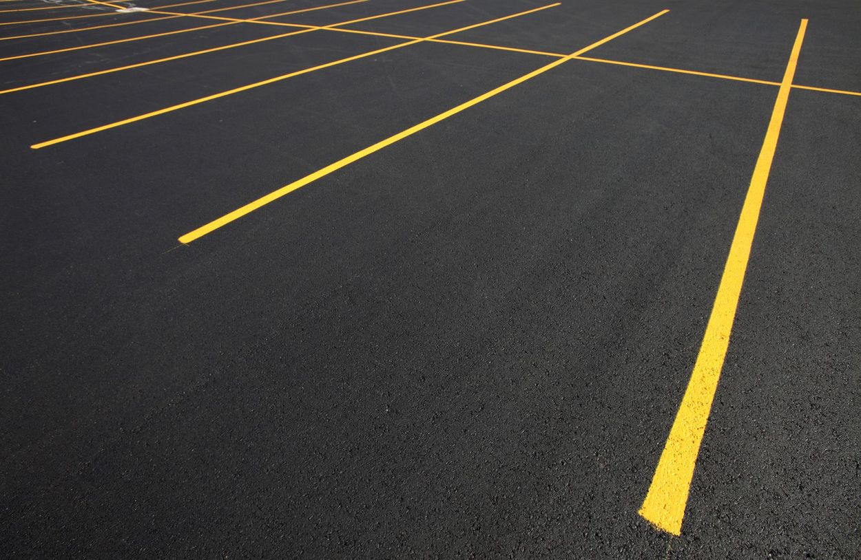 Yellow parking lines on black asphalt.