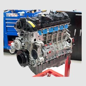 A close up of a car engine on a stand in a garage.