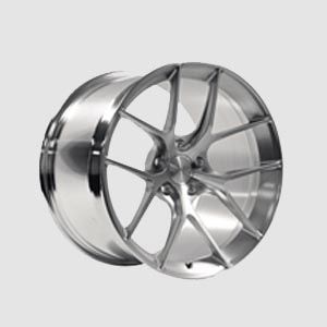 A close up of a chrome wheel on a white background.