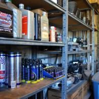 Shelves of assorted cans and bottles in a cluttered garage storage area