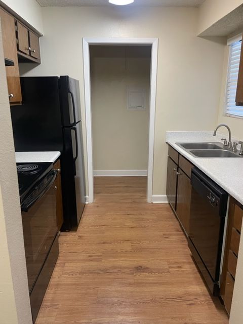A kitchen with stainless steel appliances and wooden floors