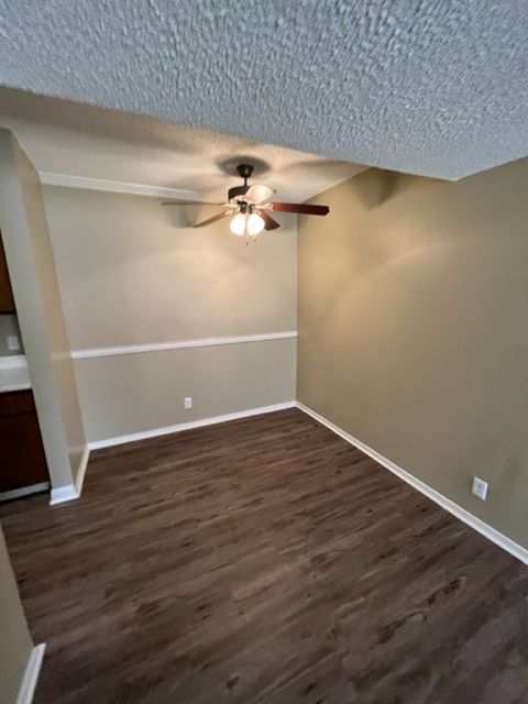 A living room with hardwood floors and a ceiling fan.