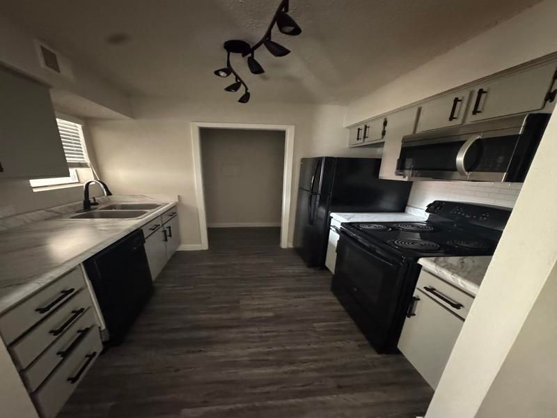 A kitchen with black appliances and white cabinets