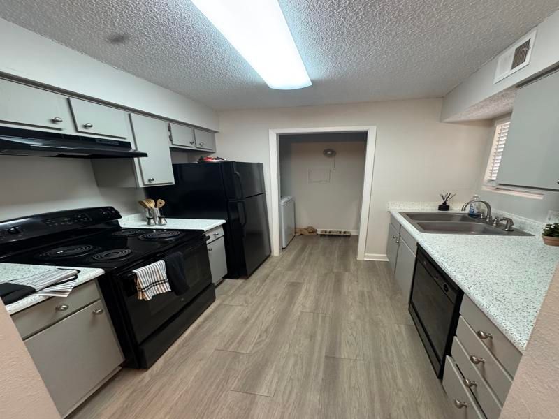 A kitchen with black appliances and white cabinets