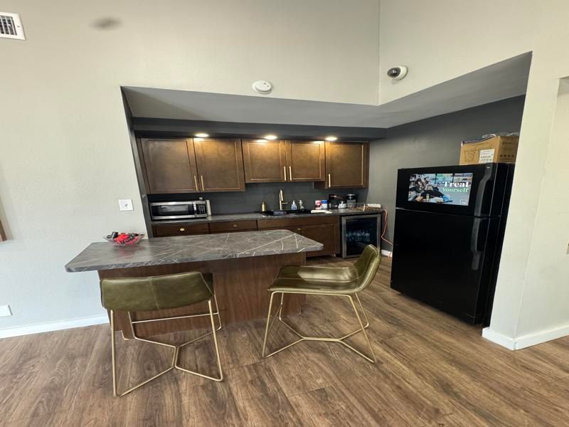 A kitchen with a table and chairs and a refrigerator.