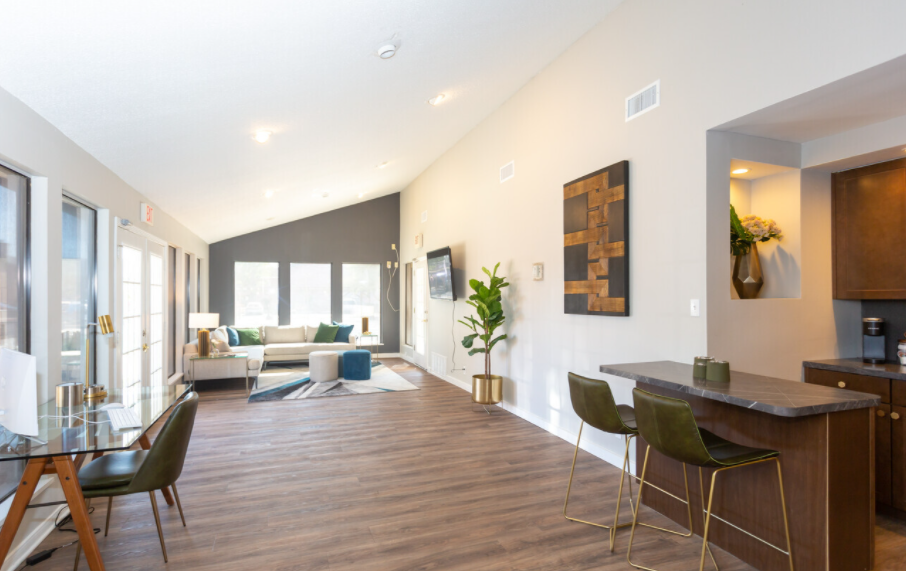 A living room with a couch , chairs , a table and a bar.