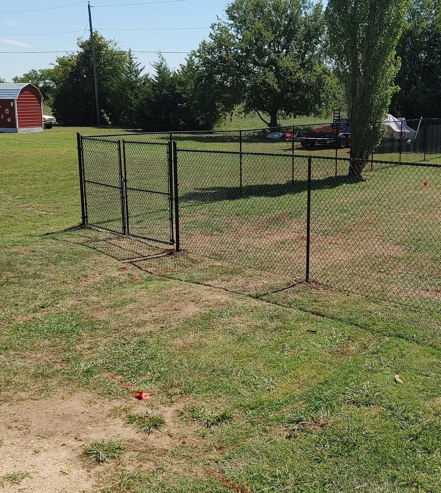 There is a fence in the middle of a grassy field.