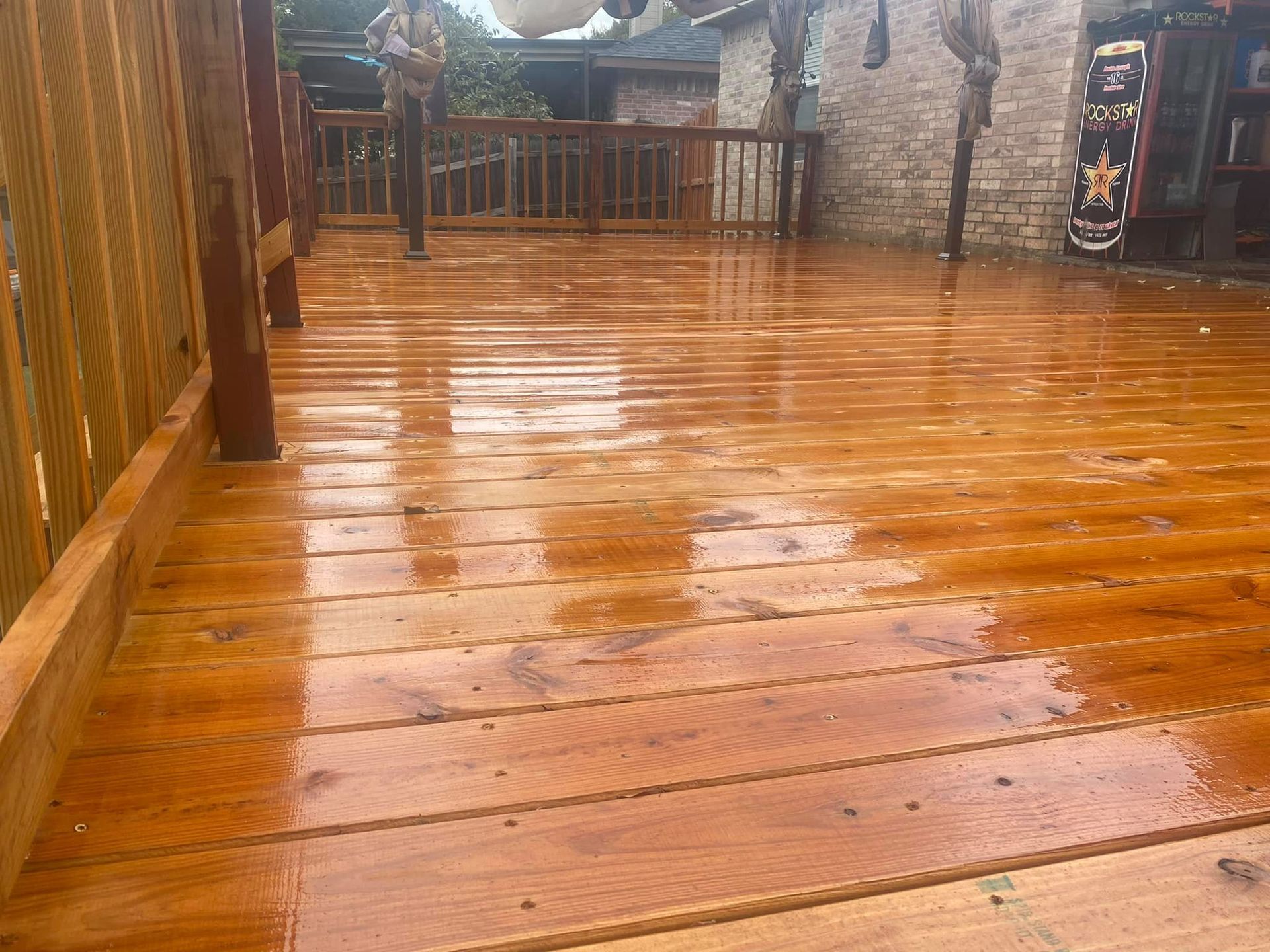 A wooden deck with a fence and a skateboard on it.