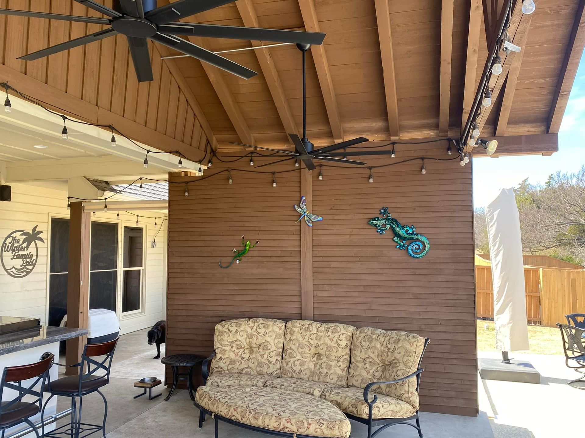 A patio with a couch , chairs and a ceiling fan.