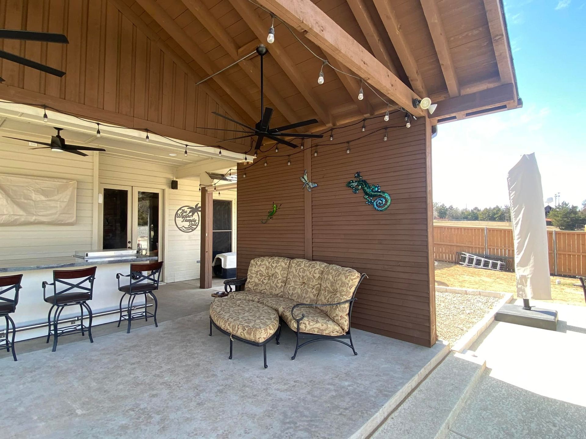 A patio with a couch , chairs and a ceiling fan.