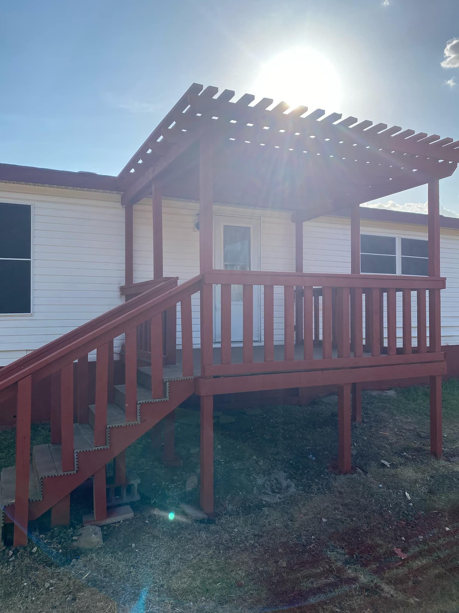 A white house with a red deck and stairs