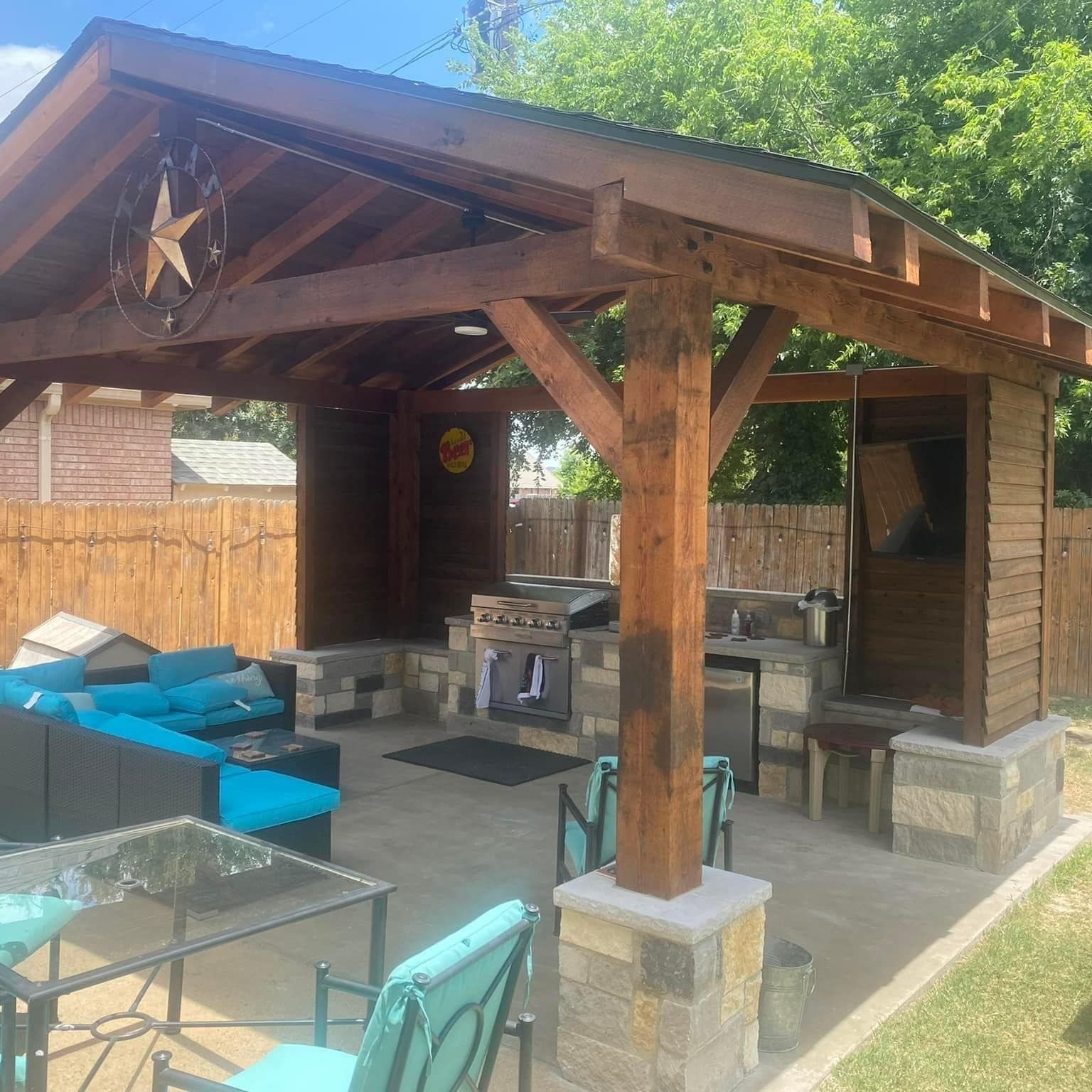 A wooden gazebo with a kitchen in the backyard