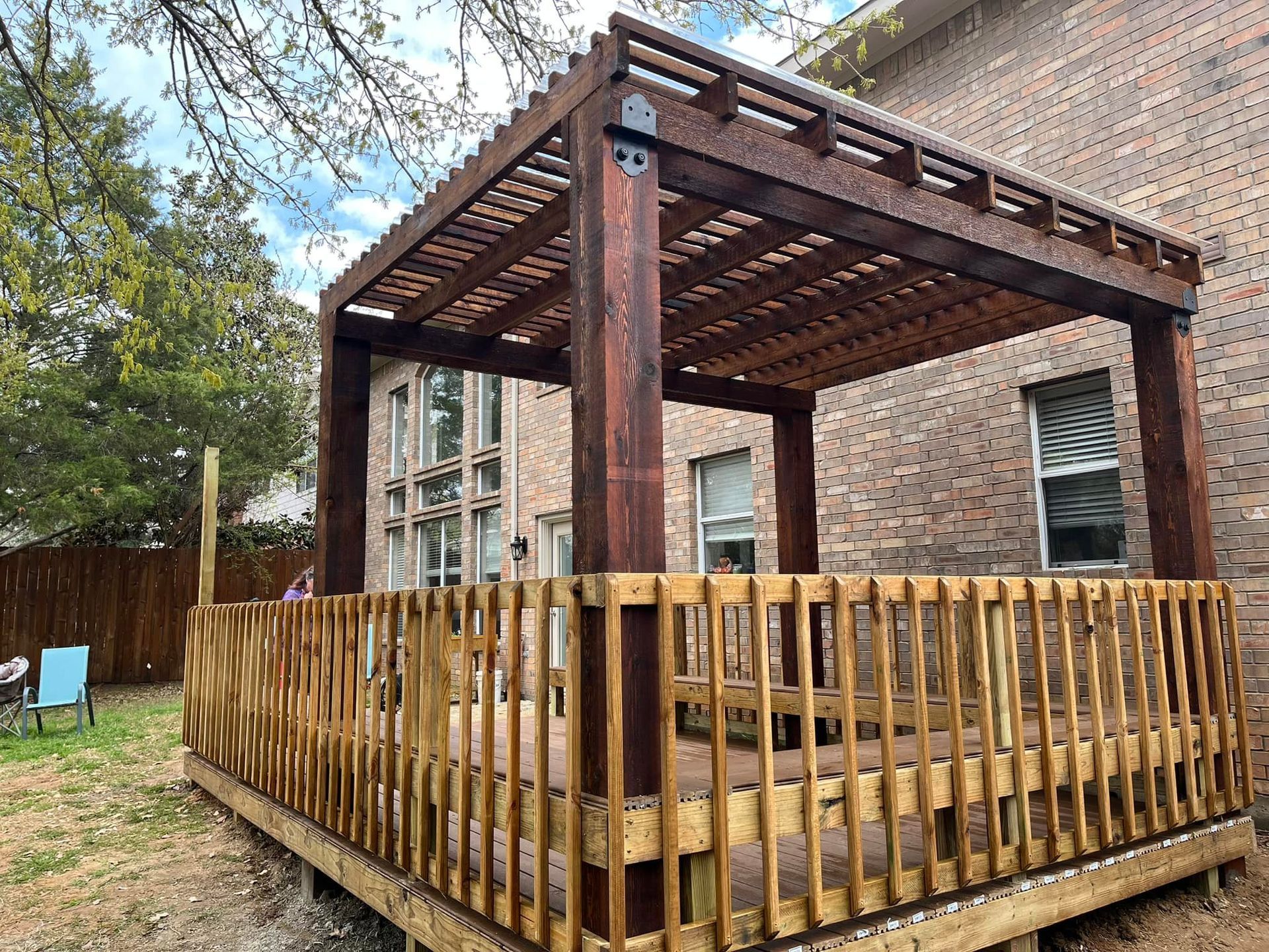 A wooden deck with a pergola on top of it.