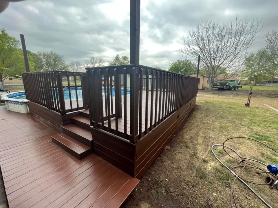 A wooden deck with stairs leading to a pool.