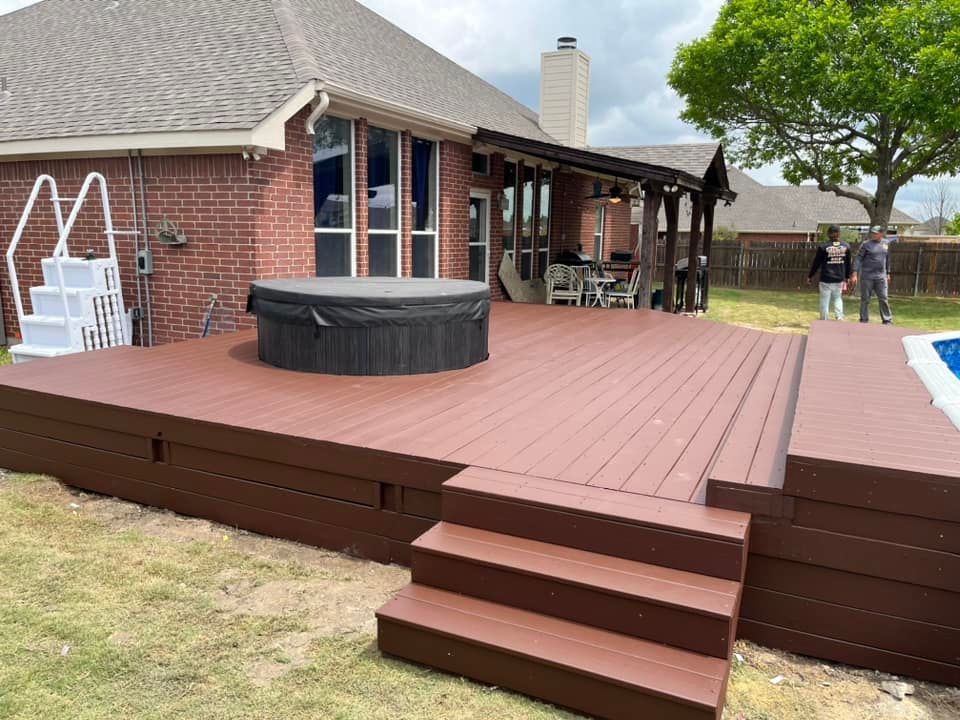 A wooden deck with stairs and a hot tub in the backyard of a house.