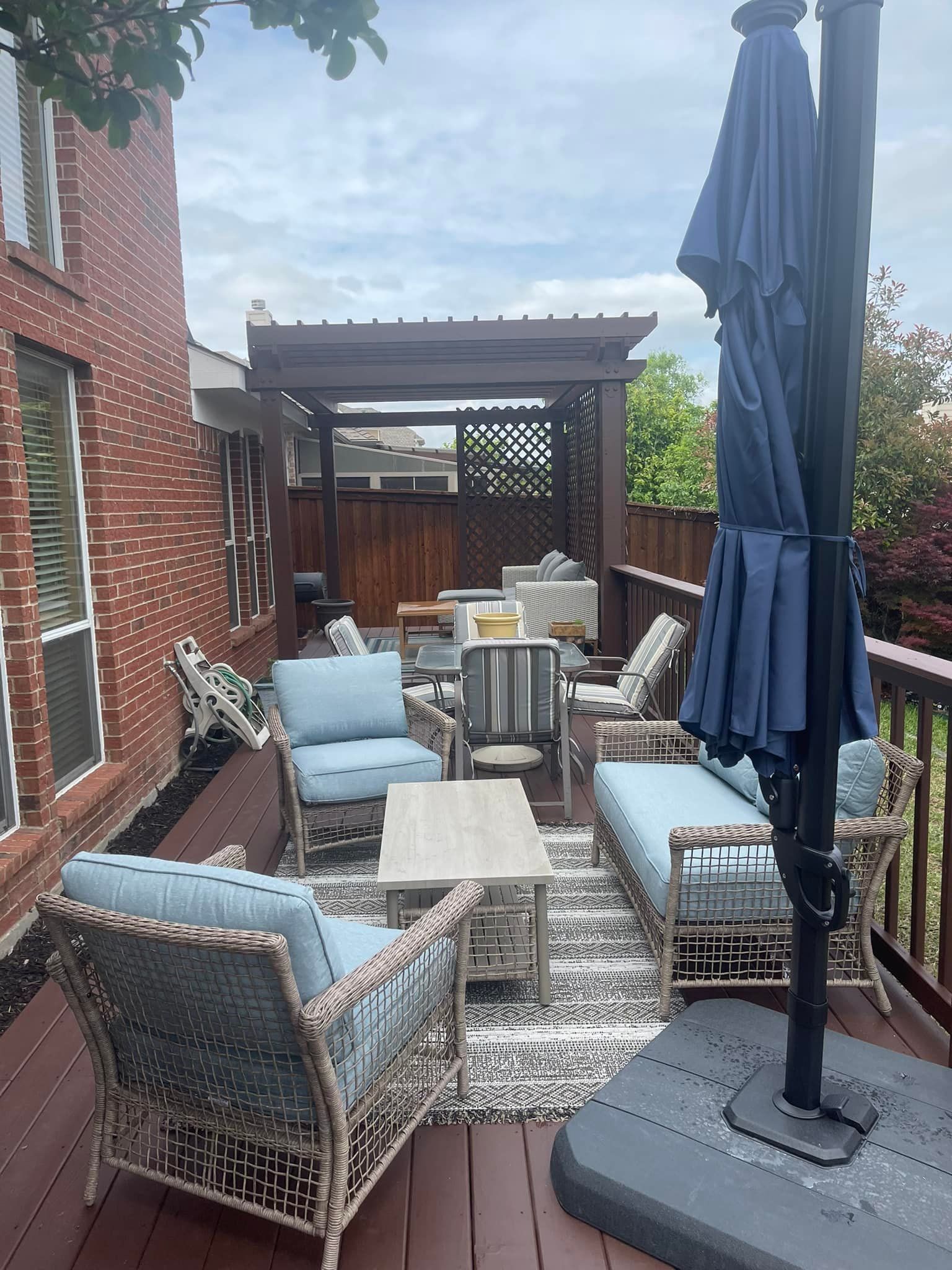 A deck with a gazebo , chairs , umbrellas and a couch.