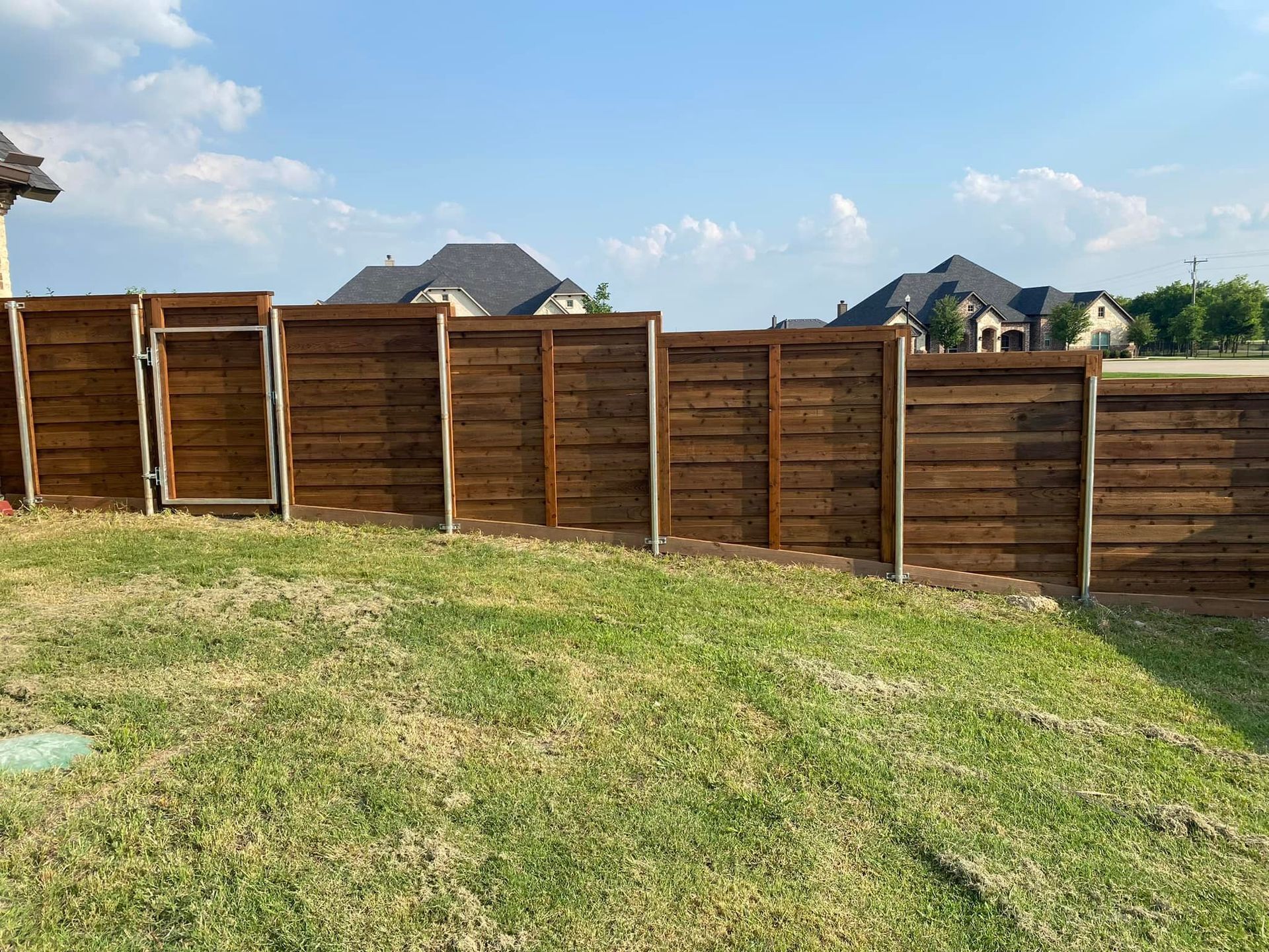 A wooden fence is sitting in the middle of a lush green field.