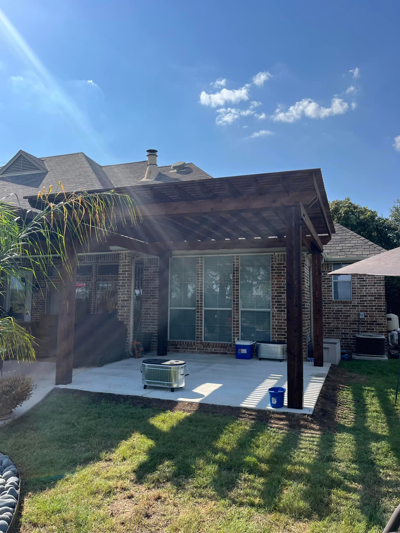 There is a pergola in the backyard of a house.