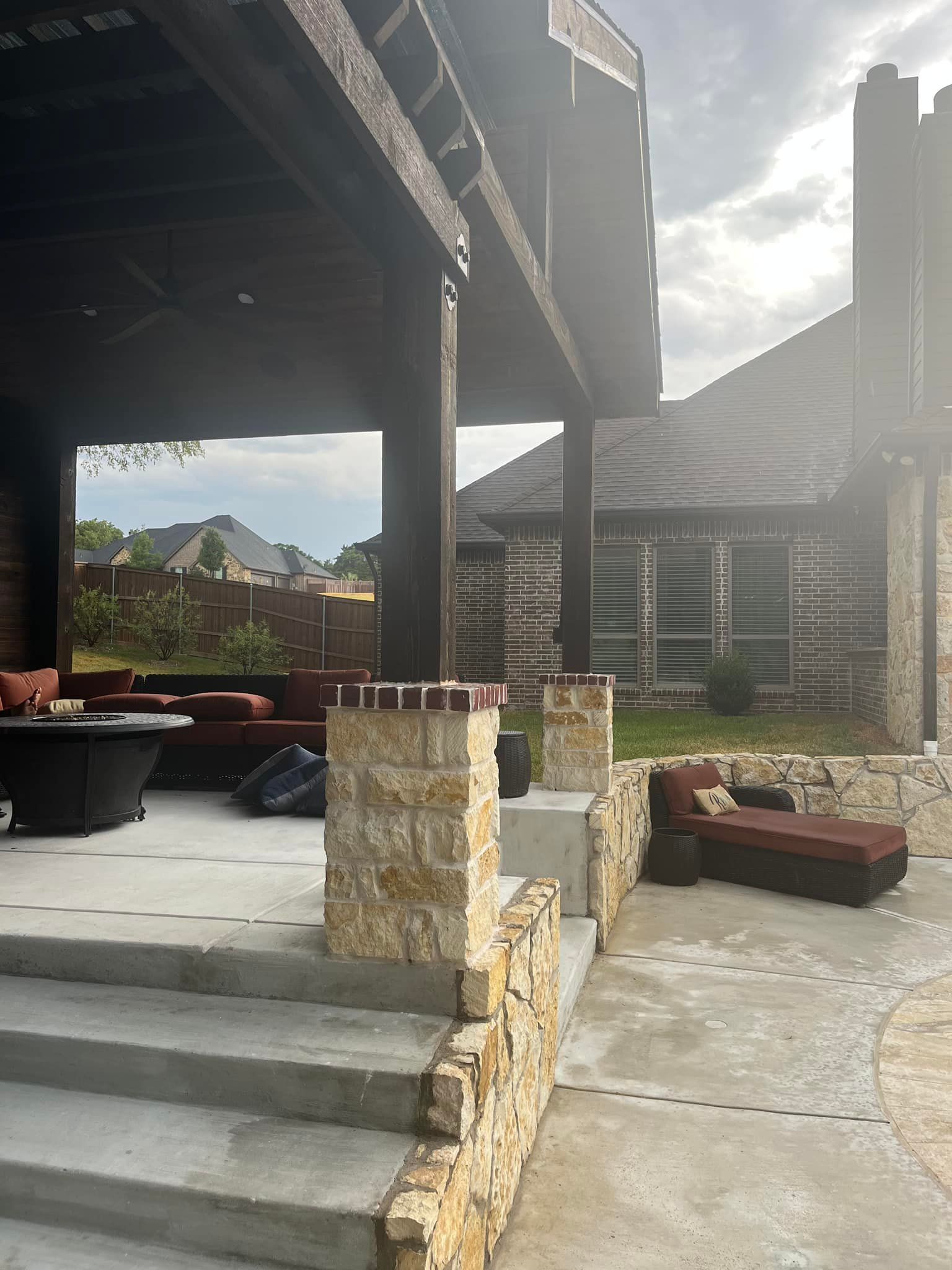 A patio with a fire pit and stairs leading up to it