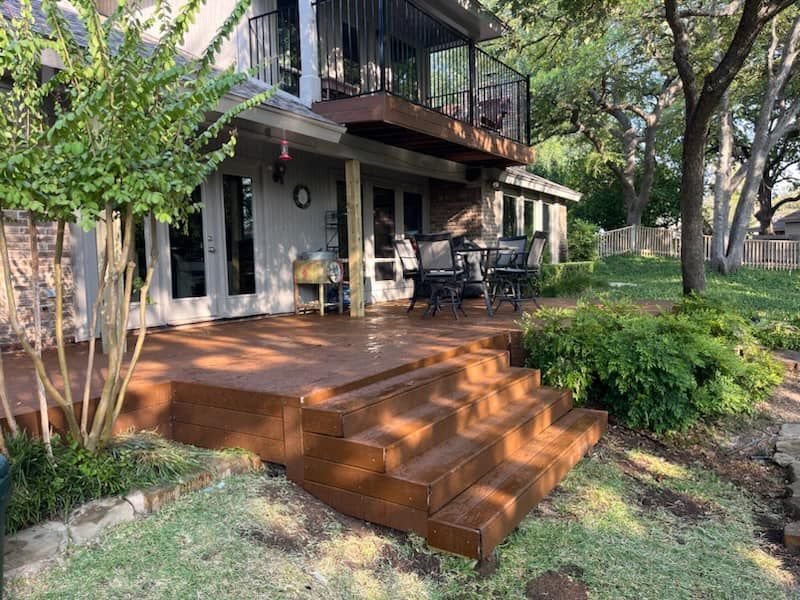 A house with a wooden deck and stairs in front of it.