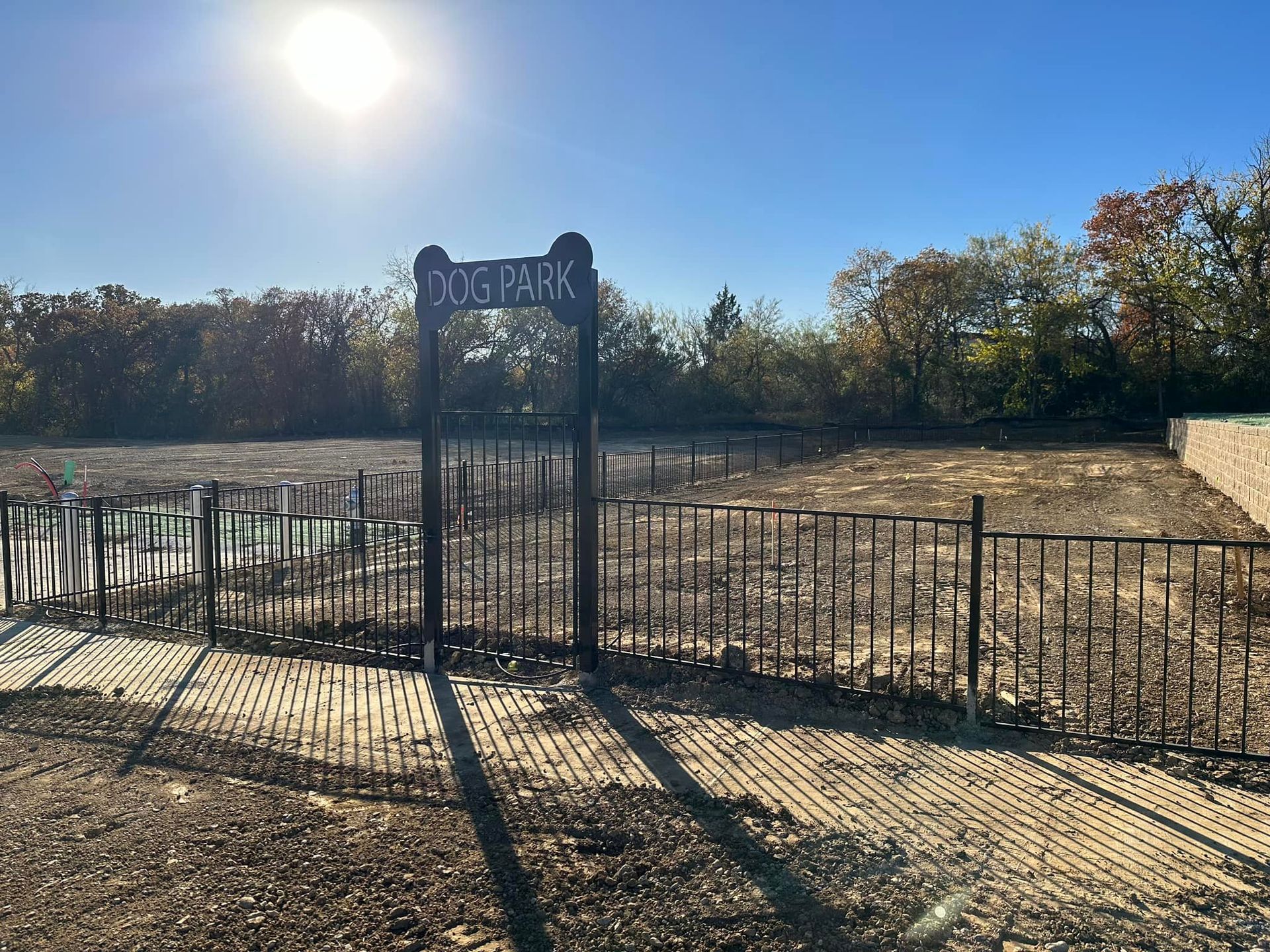 A dog park with a fence and a sign that says dog park.