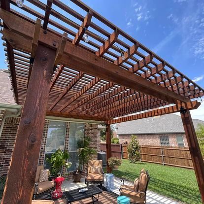 A wooden pergola is sitting on top of a patio with chairs and a table.