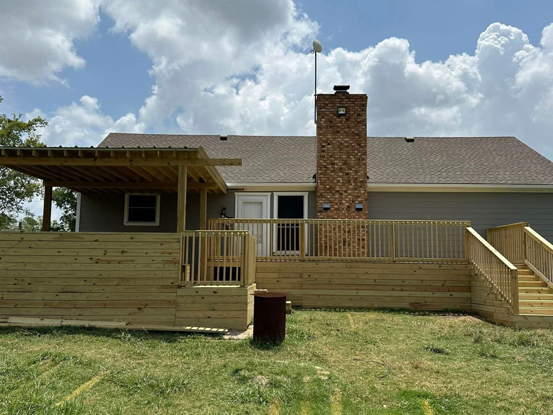 The back of a house with a wooden deck and stairs